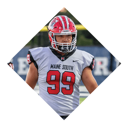 A person wearing a red and white football helmet and a white Maine South football jersey with the number 99 is standing on a field. Description generated by AI