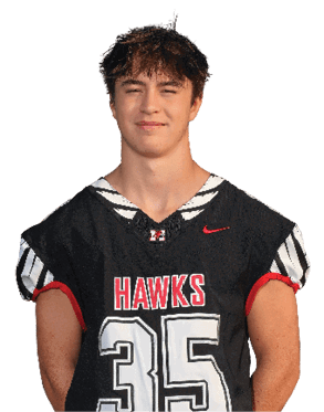 A person with short tousled hair is wearing a black sports jersey with red and white accents and the word “HAWKS" and the number 35 on the front. Description generated by AI