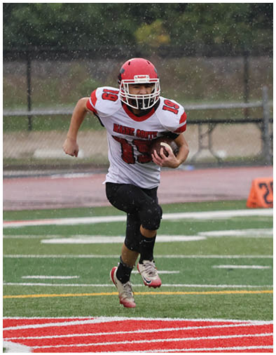 Two people wearing football helmets and uniforms are on a field with one person in a red jersey numbered 21 and the other in a white jersey numbered 23. Description generated by AI