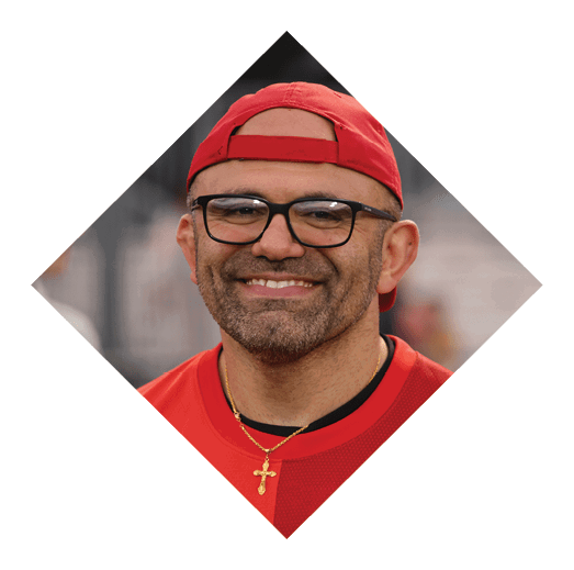 A person wearing glasses, a red cap, and a red shirt is smiling. Description generated by AI