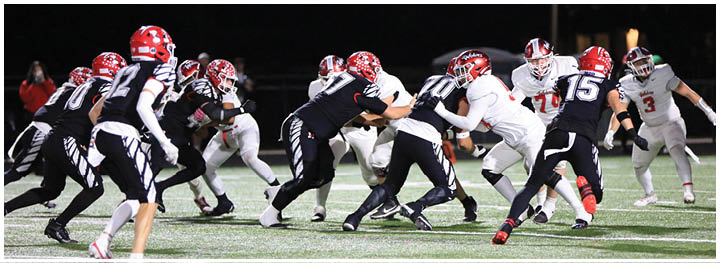 People in sports uniforms are actively running and engaging in a football game on a grassy field. Description generated by AI