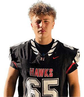A person with short, tousled hair is wearing a black football jersey with the word “HAWKS" and the number 65 on the front. Description generated by AI