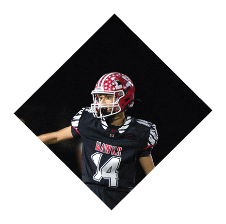A person wearing a red and white star-patterned football helmet and a black jersey with “HAWKS" and the number 14 is looking to the side against a dark background. Description generated by AI