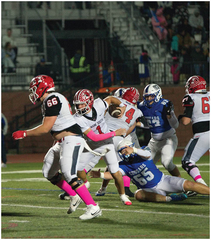 Adults in football uniforms are actively playing a game on a field with one player holding the ball while others are running and attempting to block or tackle. Description generated by AI