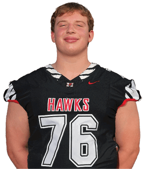 Person wearing a black sports jersey with the word “HAWKS" and the number 76 in red and white lettering. Description generated by AI