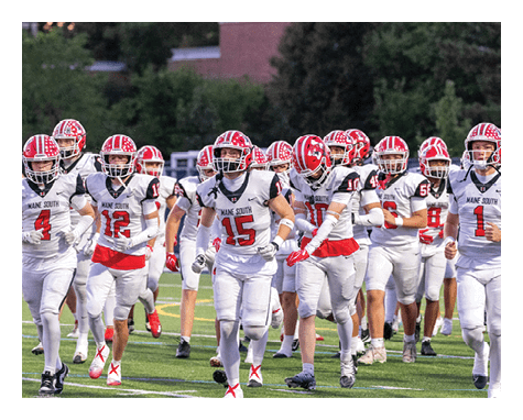 A group of people wearing white and red football uniforms with helmets are running together on a grassy field. Description generated by AI
