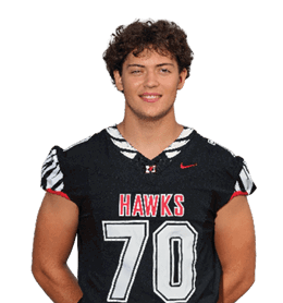 A person with curly hair is smiling and wearing a black sports jersey with the word “HAWKS" and the number 70 on the front. Description generated by AI