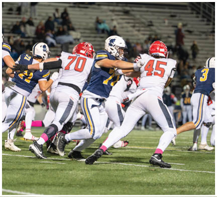 A group of football players on a field. Description generated by AI
