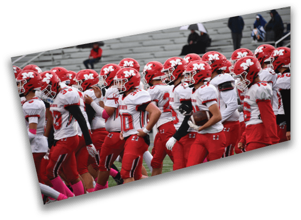 A group of people wearing red helmets and white and red football uniforms are standing closely together on a field. Description generated by AI