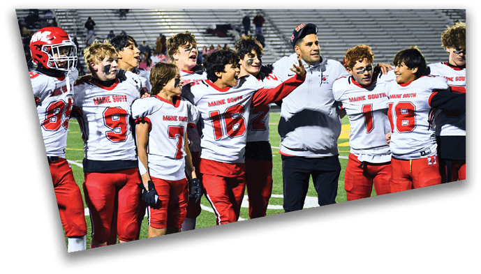 A group of people wearing red and white football uniforms with “Maine South" on the jerseys stand together on a field, some with arms around each other. Description generated by AI
