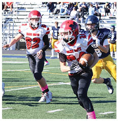 Two people wearing football uniforms with “Maine South" on the jerseys are on a football field, one running and the other preparing to move. Description generated by AI