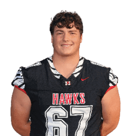A person with curly hair is standing and smiling while wearing a black football jersey with the word “HAWKS" and the number 67 on it. Description generated by AI