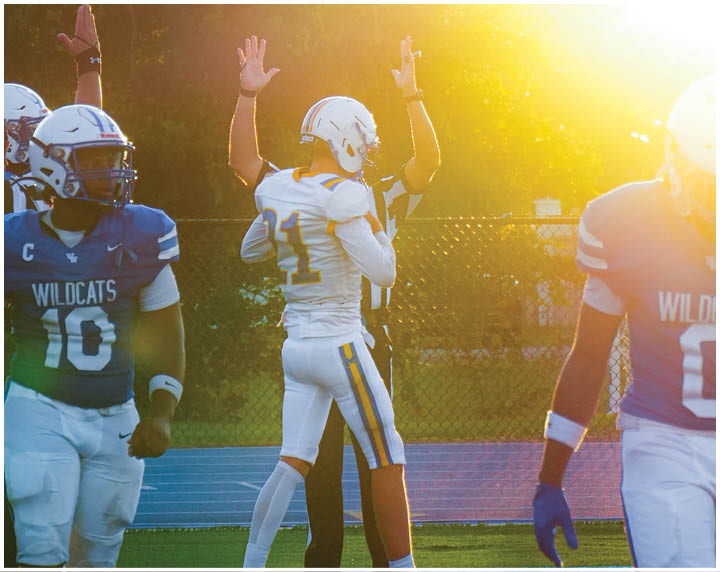 A group of football players on a field. Description generated by AI