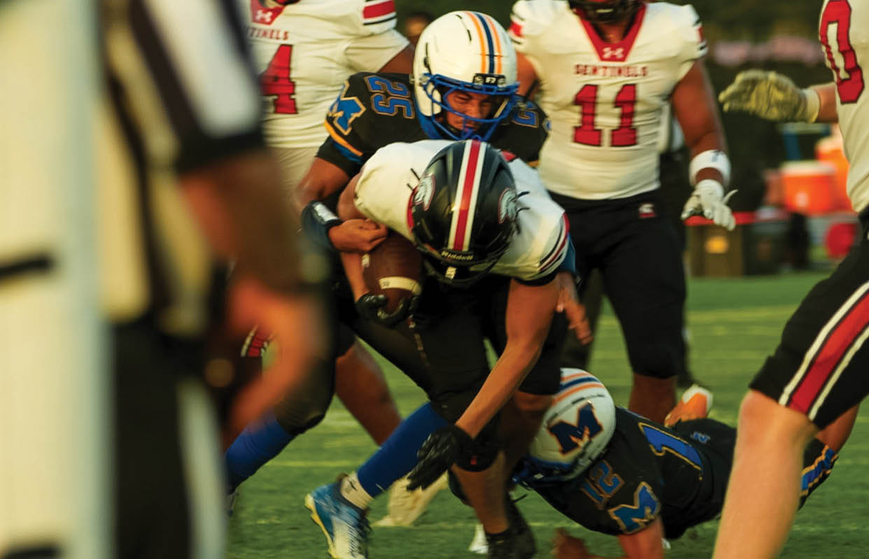 A football player wearing a black and white jersey with the number 55 on it. Description generated by AI
