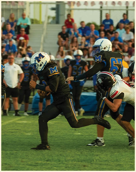 A group of football players on a field. Description generated by AI