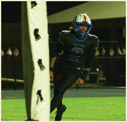 A football player is kicking a football on a field. Description generated by AI