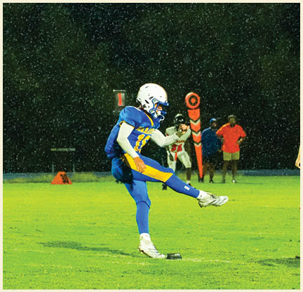 A football player is kicking a football on a field. Description generated by AI