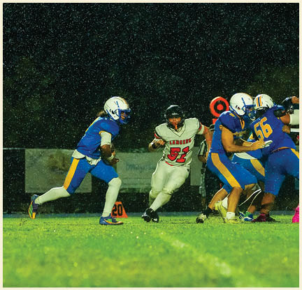 Two football players wearing black jerseys with the number 11 on them. Description generated by AI