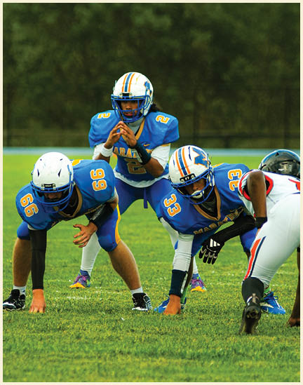 Three men wearing green and white uniforms are standing on a field. Description generated by AI