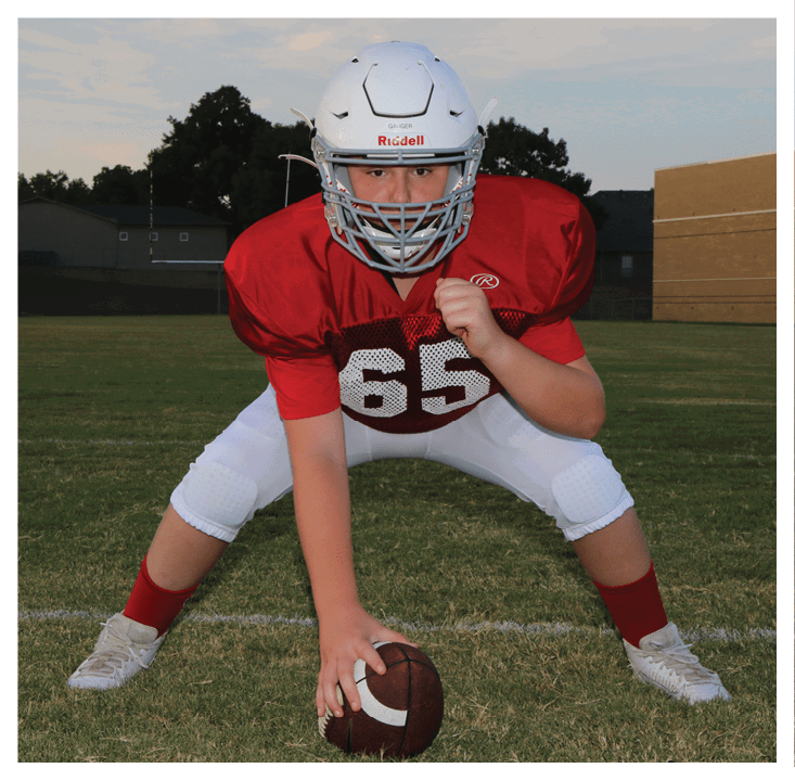 A football player wearing a blue and red jersey. Description generated by AI