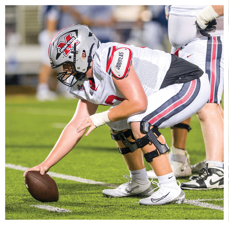 A football player wearing a blue and red jersey. Description generated by AI