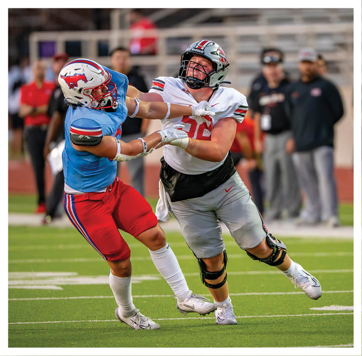 A football player wearing a blue and red jersey. Description generated by AI