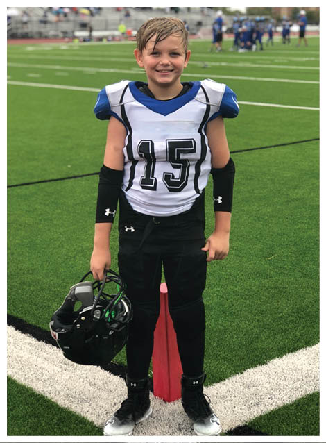 Two football players wearing black jerseys and holding hands. Description generated by AI