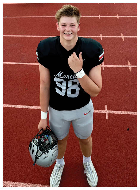 Two football players wearing black jerseys and holding hands. Description generated by AI