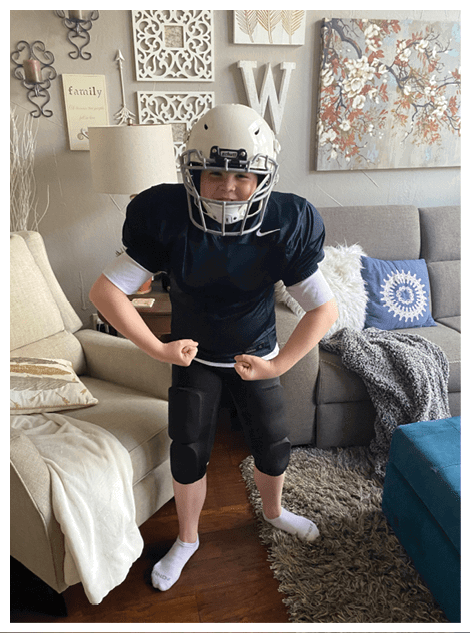 Two football players wearing black jerseys and holding hands. Description generated by AI