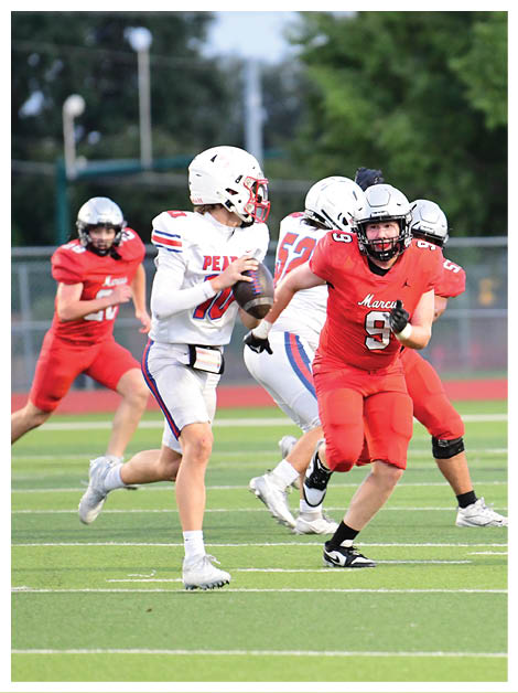 Two football players wearing black jerseys and holding hands. Description generated by AI