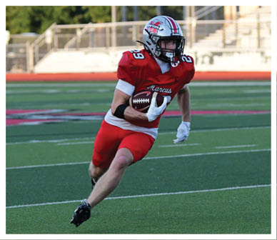 A football player wearing a blue and red jersey. Description generated by AI