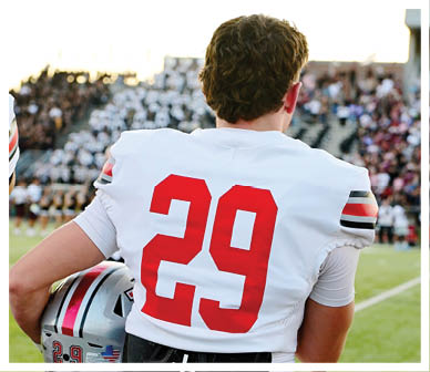 A football player wearing a blue and red jersey. Description generated by AI