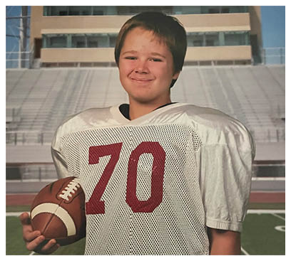 A football player wearing a blue and red jersey. Description generated by AI
