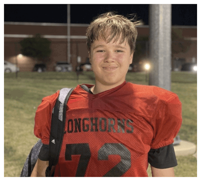 A football player wearing a blue and red jersey. Description generated by AI