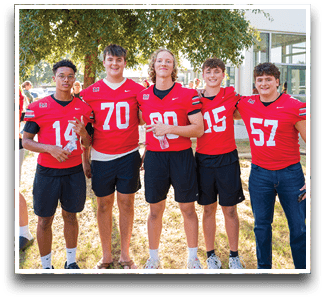 Three football players are standing on the field, one of them is smiling and wearing a black jersey with the number 55. AI generated content