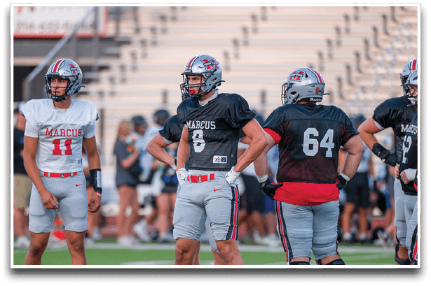 Three football players are standing on the field, one of them is smiling and wearing a black jersey with the number 55. AI generated content