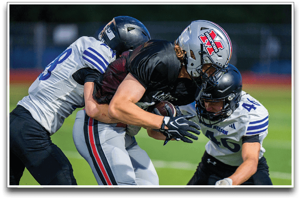 Three football players are standing on the field, one of them is smiling and wearing a black jersey with the number 55. AI generated content