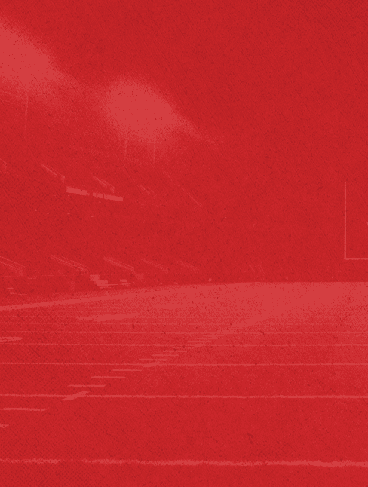 A red-tinted image of an empty football field with goalposts and stadium seating in the background. Description generated by AI