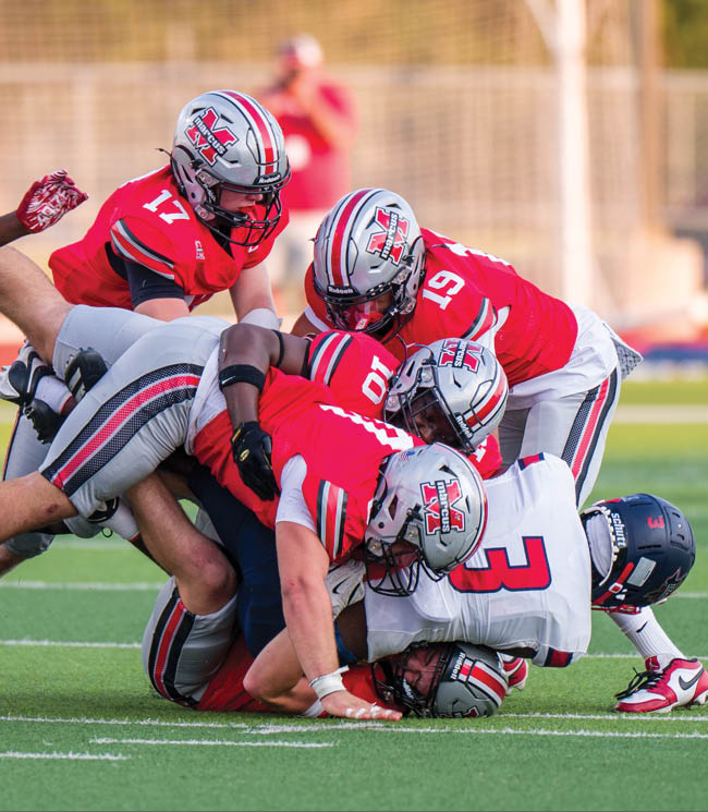 Three football players are standing on the field, one of them is smiling and wearing a black jersey with the number 55. AI generated content