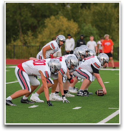 Three football players are standing on the field, one of them is smiling and wearing a black jersey with the number 55. AI generated content