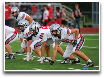Three football players are standing on the field, one of them is smiling and wearing a black jersey with the number 55. AI generated content