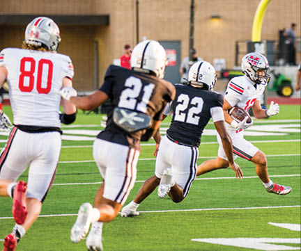 Three football players are standing on the field, one of them is smiling and wearing a black jersey with the number 55. AI generated content