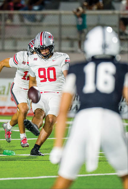 Three football players are standing on the field, one of them is smiling and wearing a black jersey with the number 55. AI generated content