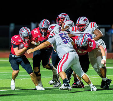 Three football players are standing on the field, one of them is smiling and wearing a black jersey with the number 55. AI generated content
