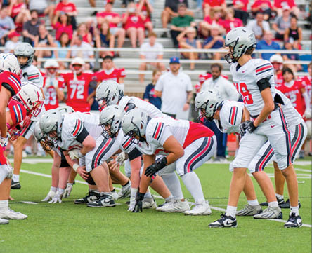 Three football players are standing on the field, one of them is smiling and wearing a black jersey with the number 55. AI generated content