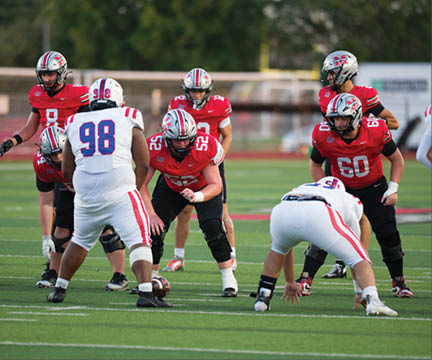 Three football players are standing on the field, one of them is smiling and wearing a black jersey with the number 55. AI generated content
