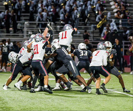 Three football players are standing on the field, one of them is smiling and wearing a black jersey with the number 55. AI generated content