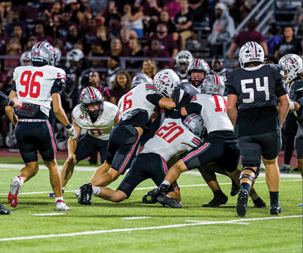 Three football players are standing on the field, one of them is smiling and wearing a black jersey with the number 55. AI generated content