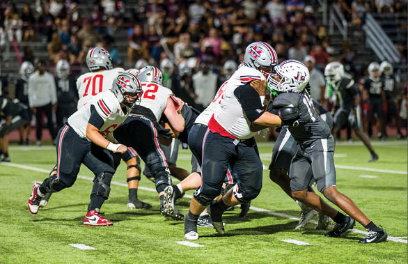 Three football players are standing on the field, one of them is smiling and wearing a black jersey with the number 55. AI generated content