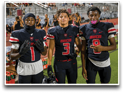 Three football players are standing on the field, one of them is smiling and wearing a black jersey with the number 55. AI generated content